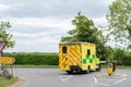 Emergency ambulance seen following a Diversion Sign at a urban road junction.