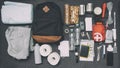 Emergency backpack equipment organized on the table. Documents, water,food, first aid kit and another items Royalty Free Stock Photo