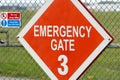 Emergency crash gate at airport runway red diamond warning sign. Gates number 3 information red and white words three.