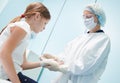 female surgeon doctor, in focus, bandaging child& x27;s hand in clinic Royalty Free Stock Photo