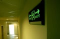 Emergency exit sign in a building glowing green Royalty Free Stock Photo
