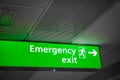 Emergency exit sign glowing green  in airport- for safety Royalty Free Stock Photo