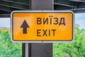 emergency exit sign in yellow board hanging on a ceiling Royalty Free Stock Photo