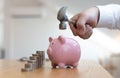 Emergency finance, Businessman using a hammer is about to destroy the pink piggy bank