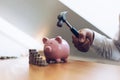 Emergency finance, Businessman using a hammer is about to destroy the pink piggy bank