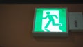 Emergency fire exit sign direction to doorway in the building .It green color light in japan Royalty Free Stock Photo