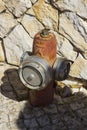 An emergency fire hydrant located in front of a stone wall in Albuferia in Portugal. Royalty Free Stock Photo