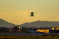 Emergency helicopter, firefighters, with the last hours of the sunset sun performing the maneuvers to land on the runway of the