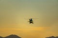 Emergency helicopter, firefighters, with the last hours of the sunset sun performing the maneuvers to land on the runway of the