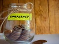 Emergency label on coins jar with vintage background. Financial management concept. Royalty Free Stock Photo