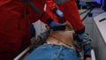 Emergency medical doctors using heart defibrillator on patient in ambulance car Royalty Free Stock Photo