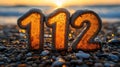 Emergency numbers 112 at sunrise beach Royalty Free Stock Photo