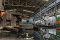 emergency pollution factory concept. Female chemist wearing PPE and gas mask inspecting oil on factory floor