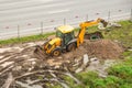 Emergency repair work of main urban heat pipes on the lawn nearby. Working tractor excavator digs a pit trench at site of heating Royalty Free Stock Photo