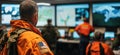 Emergency response team monitoring operations in control room with multiple screens displaying maps and data, copy space Royalty Free Stock Photo