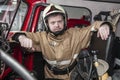 Emergency safety. Protection, rescue from danger. Fire fighter in protective helmet. Fire truck ready to respond to emergency, Royalty Free Stock Photo