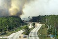 Emergency service firetrucks extinguishing wildfire burning in Florida jungle woods. Fire department vehicles trying to