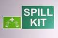 Emergency spill kit wall signs in green on off white background