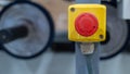 Emergency stop button on industrial machine with blurred rollers in background Royalty Free Stock Photo