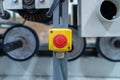 Emergency stop button on industrial machine with rollers in background Description: Royalty Free Stock Photo