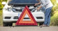 Emergency stop sign and driver near broken car on road Royalty Free Stock Photo