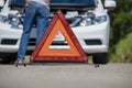 Emergency stop sign and driver near broken car on road Royalty Free Stock Photo