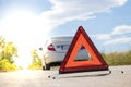 Emergency stop sign near broken car on road. Royalty Free Stock Photo