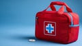 Emergency-themed image featuring a red first aid kit centered on a clean blue backdrop Royalty Free Stock Photo