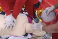 Emergency worker pressing on sufferers chest, keeping an oxygen cushion on his face. Artificial respiration