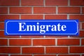 Emigrate street sign on brick wall