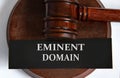 EMINENT DOMAIN - words on a black sheet against the background of a judge\'s gavel