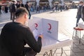 Eminonu, Istanbul, Turkey - 02.26.2021: a male blood donation volunteer sits and reads permission form of Turkish Red Crescent