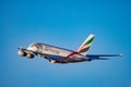 An Emirates Airbus A380 decorated with the special Museum of the Future livery flies against a bright blue sky