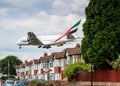 Emirates Airbus A380 plane landing over houses Royalty Free Stock Photo