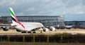 An Emirates Airline A380 Airbus taxis in front of the new commercial aviation hangar currently under construction at Gatwick