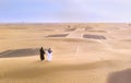 Emirati couple on a sandy road near Dubai