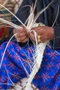 Emirati woman is weaving traditional basket from palm leaves