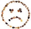 Emoji emoticon of sad face handmade with stones boulders. Isolated on white background. Collection made with stones