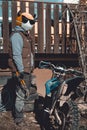 Emoji motocross rider with fancy black nerd sunglasses, preparing his motorcycle for a race