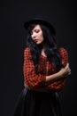 Emotion brunette female model posing in black hat with red bright lipstick on black background. Art fashion portrait. Royalty Free Stock Photo