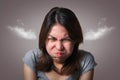 Emotion concept, Portrait of angry cute asian woman posing looking at camera with grey clothes on gray background