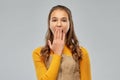 Teenage girl closing her mouth by hand or yawning Royalty Free Stock Photo