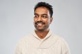 Indian man in knitted sweater over gray background