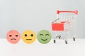 Emotion face on circle paper cut and red shopping cart for positive thinking ,customer review, experience, satisfaction survey Royalty Free Stock Photo