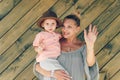 Emotion portrait grandmother and his granddaughter in rural style muslin clothers on green wooden background