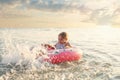 Emotional active little child girl splashing in the sea on a sunny summer during the holidays. The concept of family holidays with Royalty Free Stock Photo