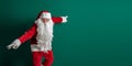 Emotional actor in costume of Santa Claus with long beard gestures and poses on green background