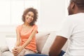 Emotional black couple talking on sofa at home Royalty Free Stock Photo