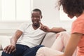 Emotional black couple talking on sofa at home Royalty Free Stock Photo