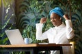 Emotional african american lady celebrating success, working at cafe Royalty Free Stock Photo